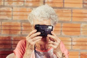 an old woman using a camera
